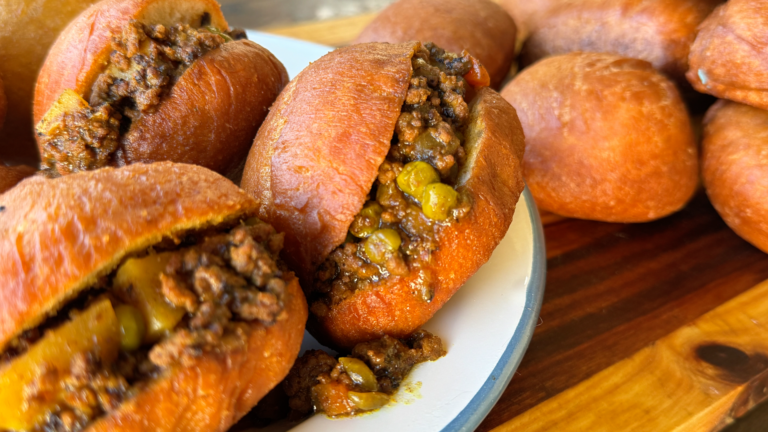 Golden vetkoek fried bread stuffed with curry mince over fir